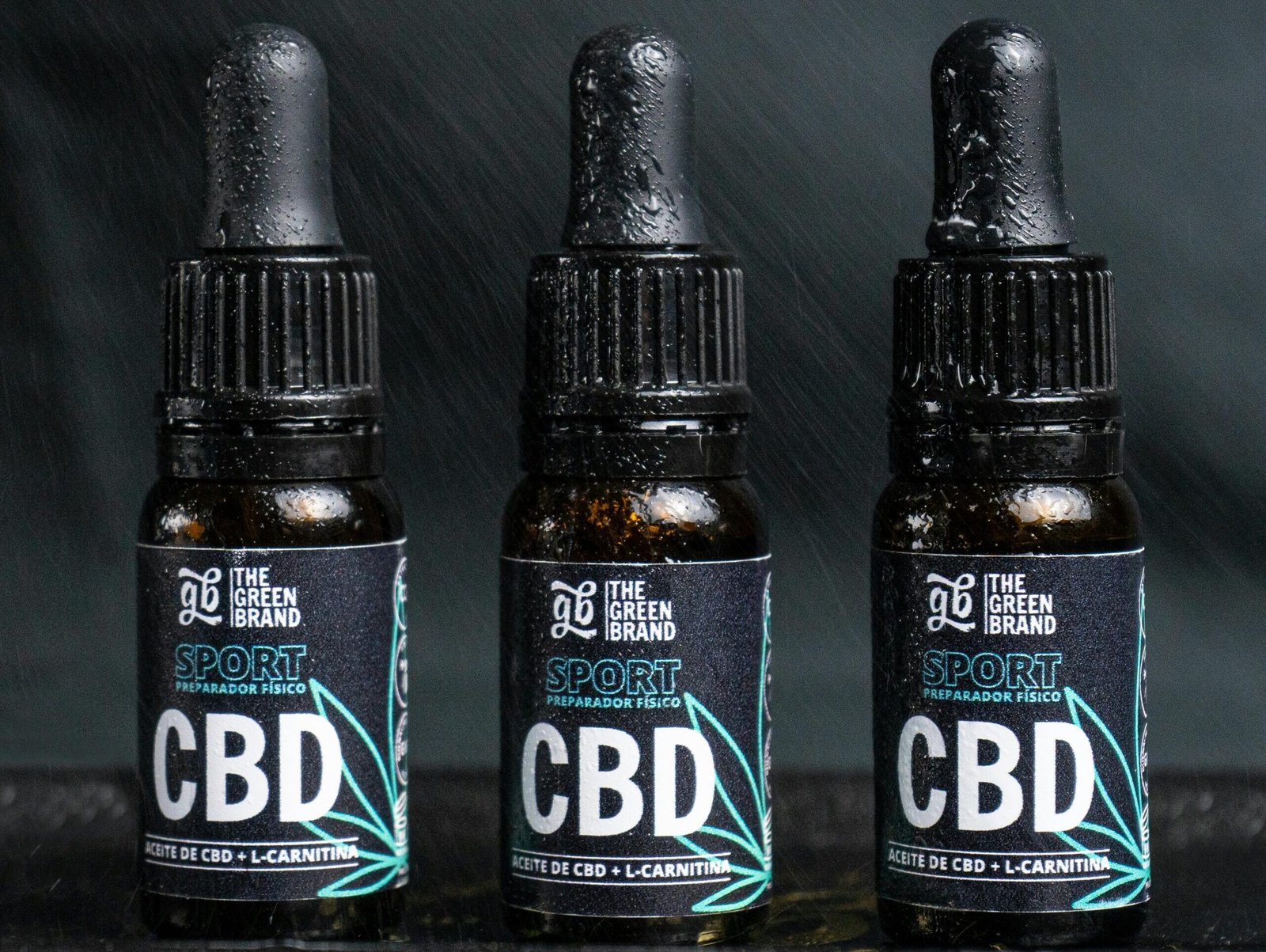 Close-up of three CBD oil bottles labeled for sports recovery and fitness.